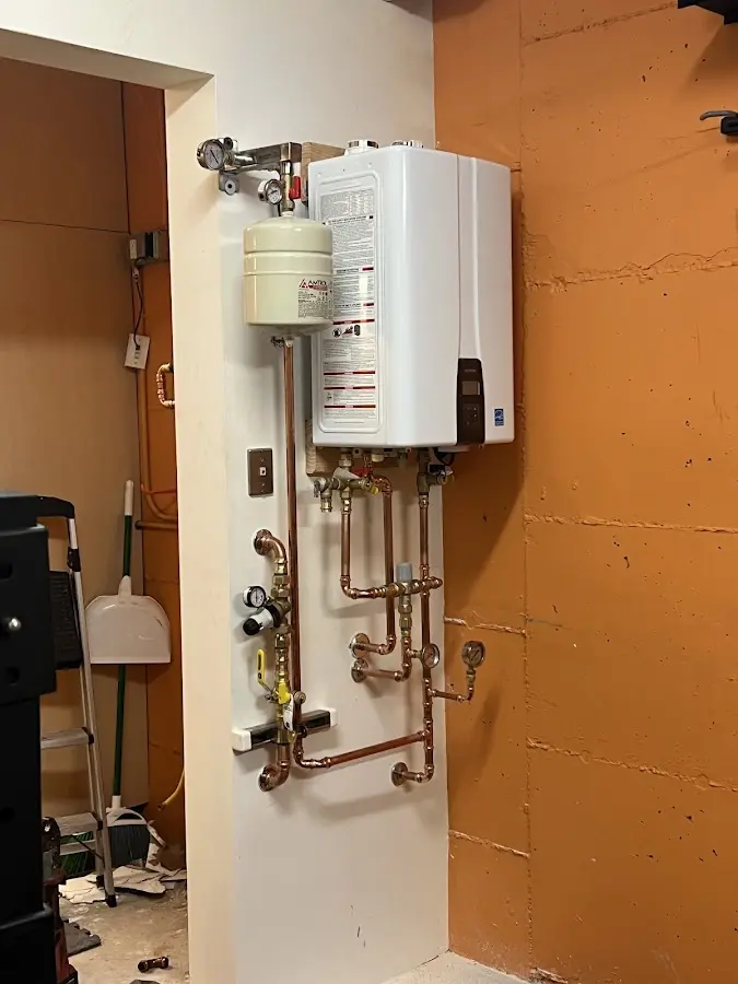 Plumbing technician inspecting water heater connections in Coolidge